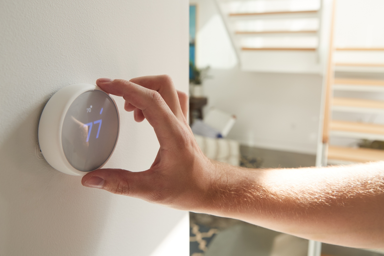 hand reaching for a smart thermostat