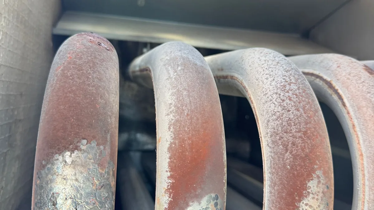 New run capacitor being installed in a central air conditioner compressor unit during GTA AC repair