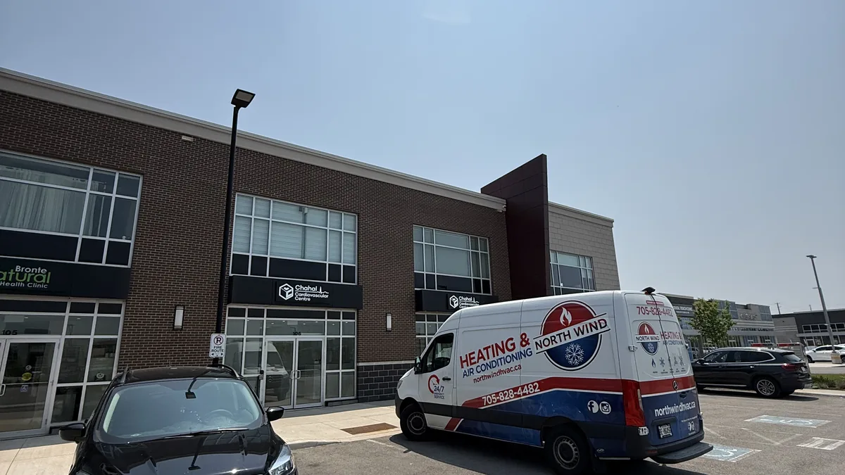 HVAC technician adjusting duct damper to balance airflow between rooms in a Toronto area home