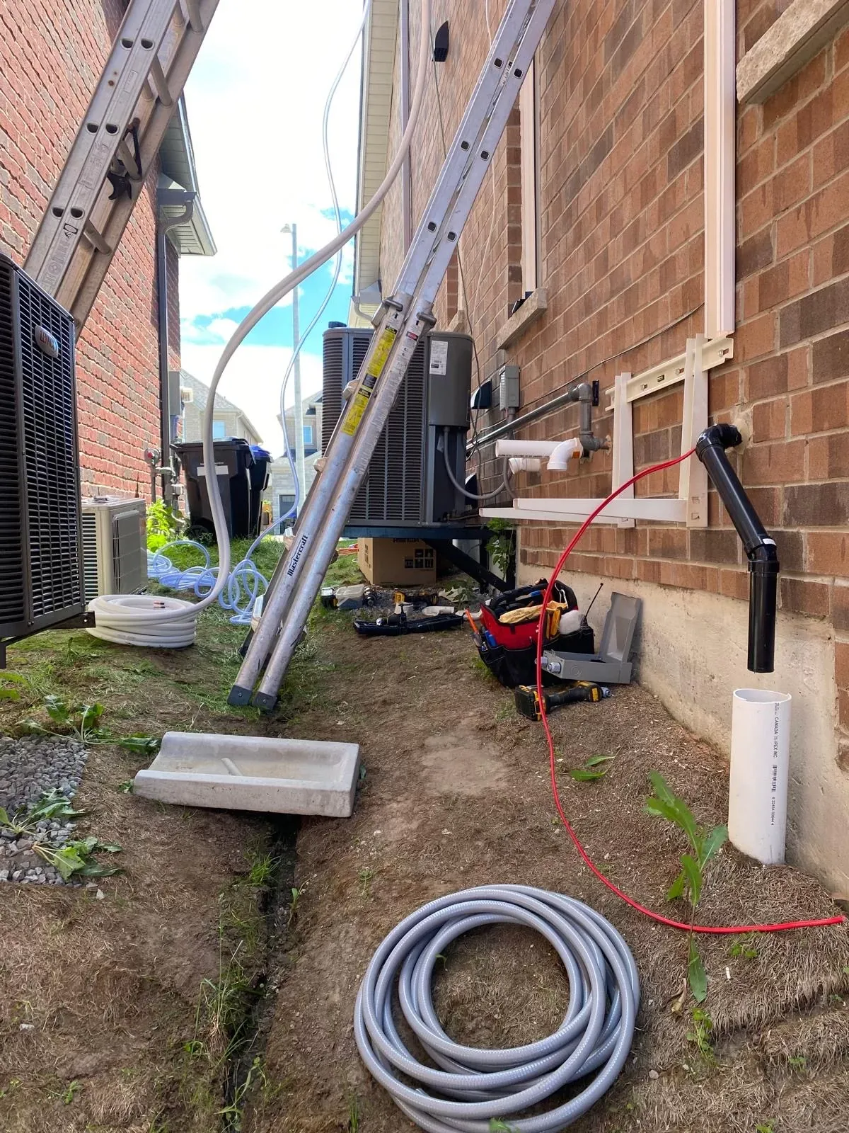 Refrigerant line set and condensate drain being run during a heat pump installation